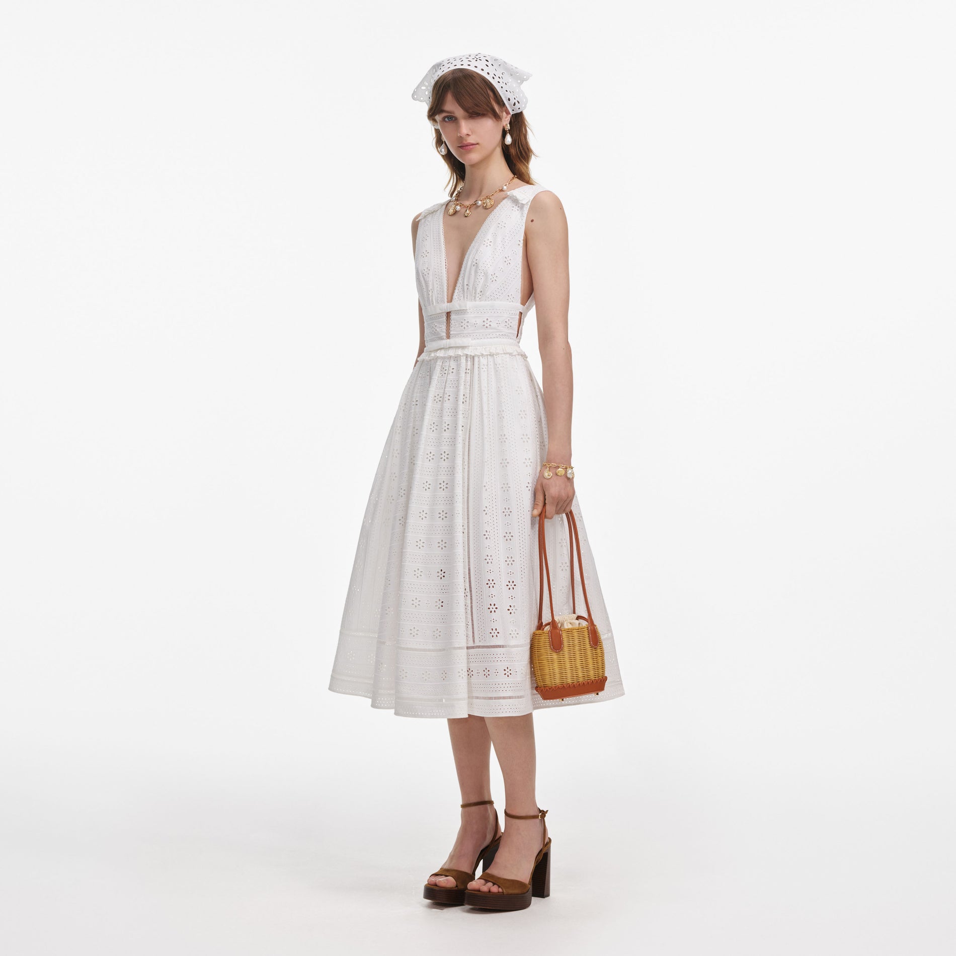 Side view of a woman wearing the White Cotton Broderie Midi Dress