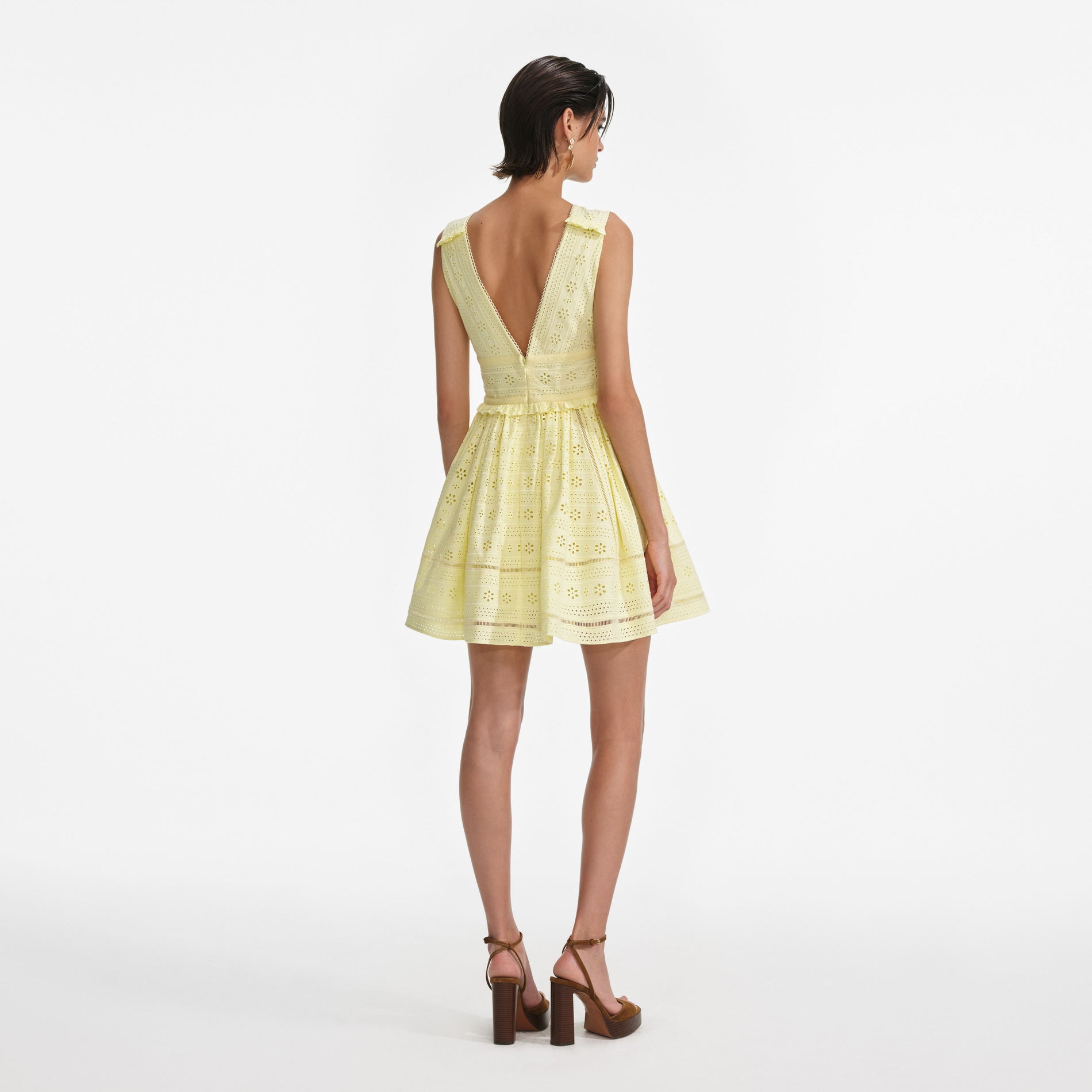 Back view of a woman wearing the Yellow Cotton Broderie Mini Dress