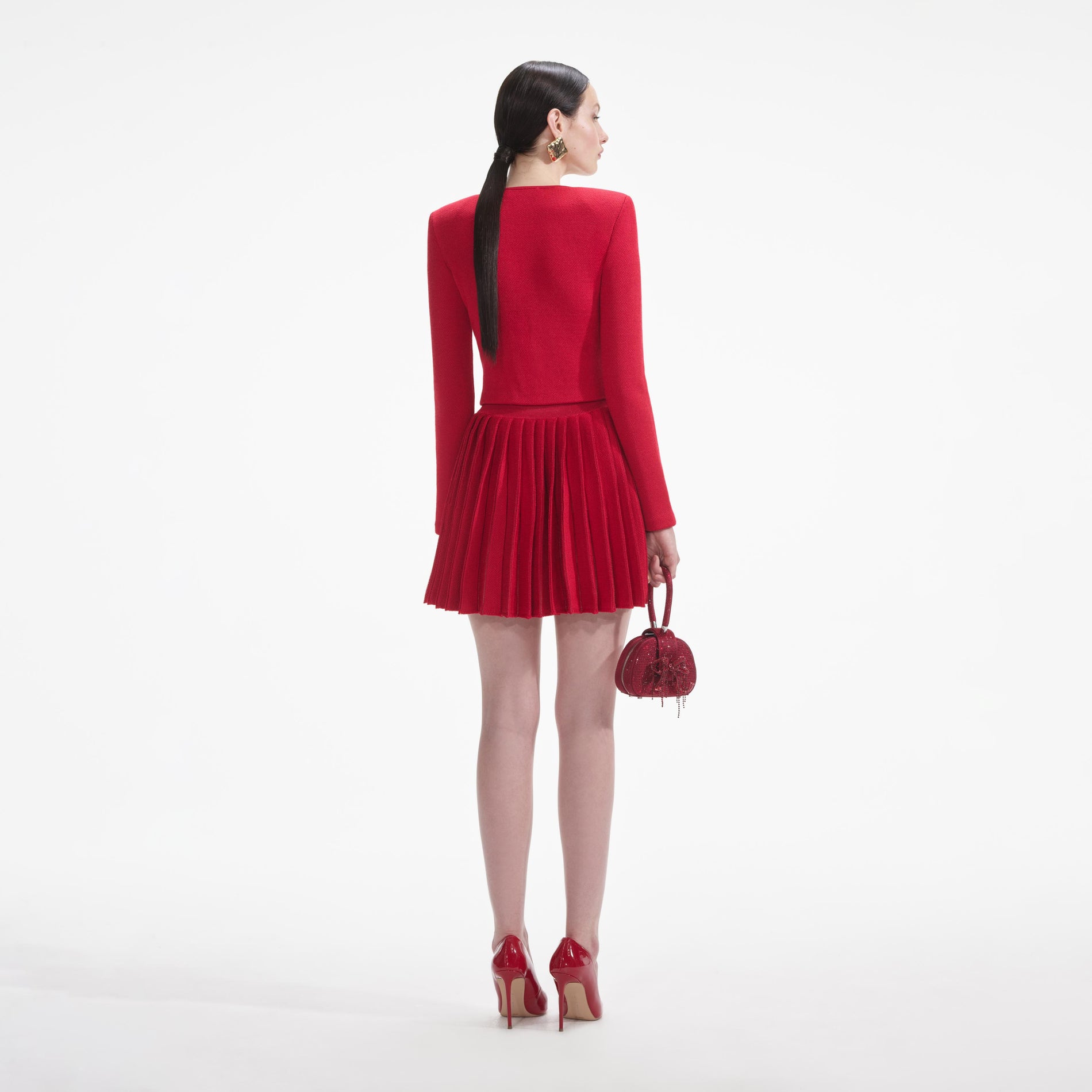 Back view of a woman wearing the White Red Pleated Knit Mini Skirt