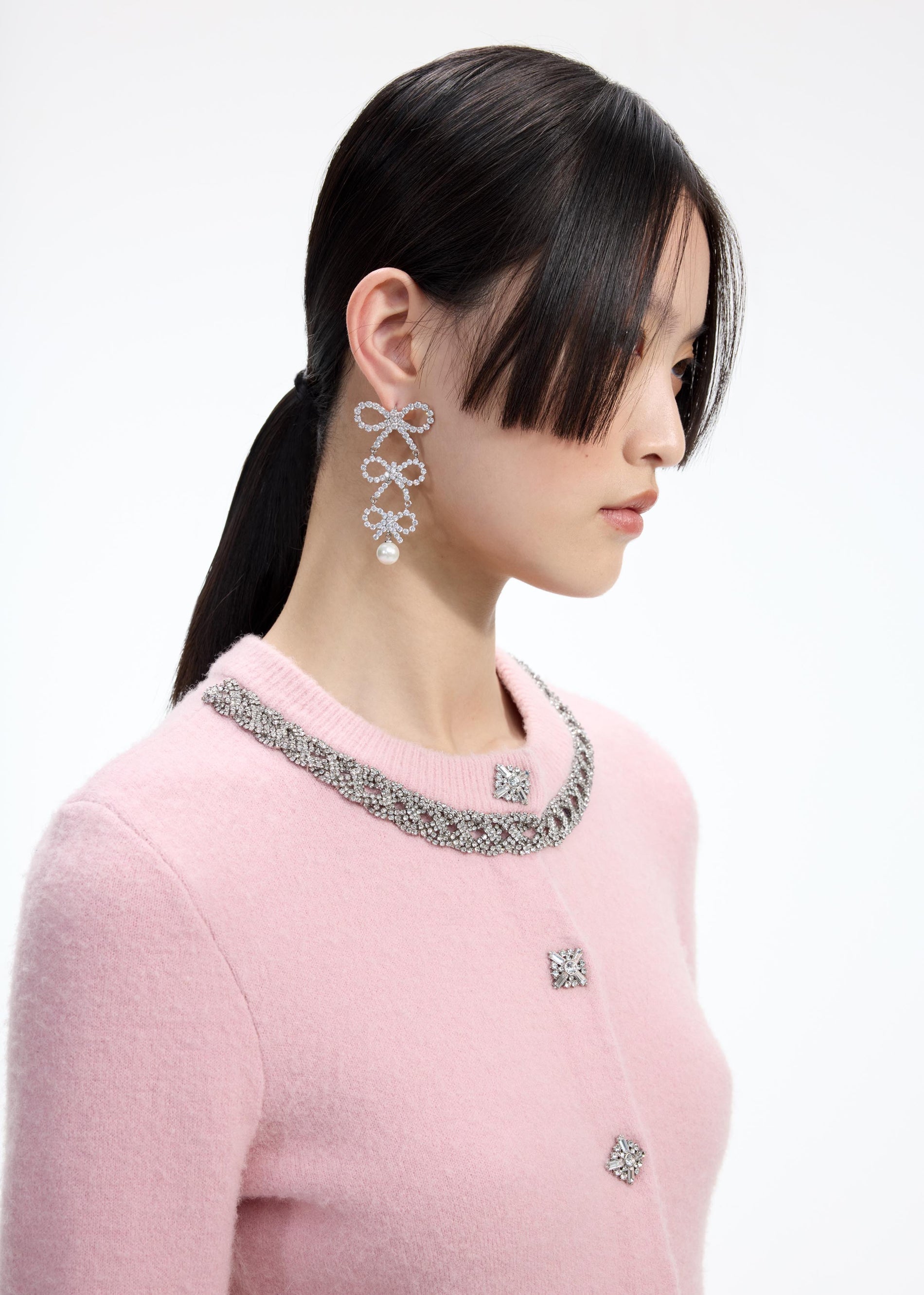 Back view of a woman wearing the Tiered Crystal Bow Earrings