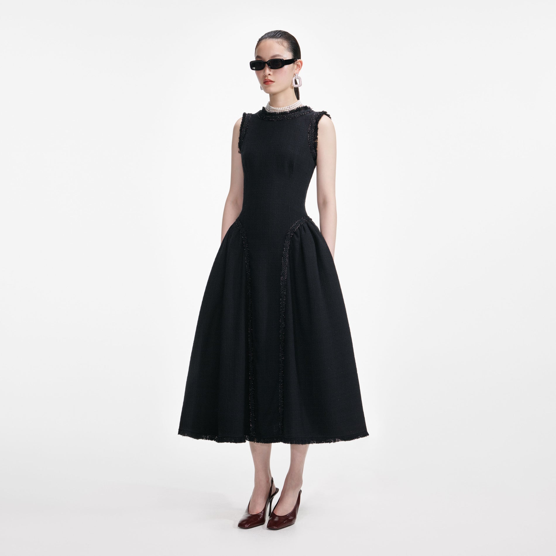 Side view of a woman wearing the Black Boucle Sleeveless Midi Dress