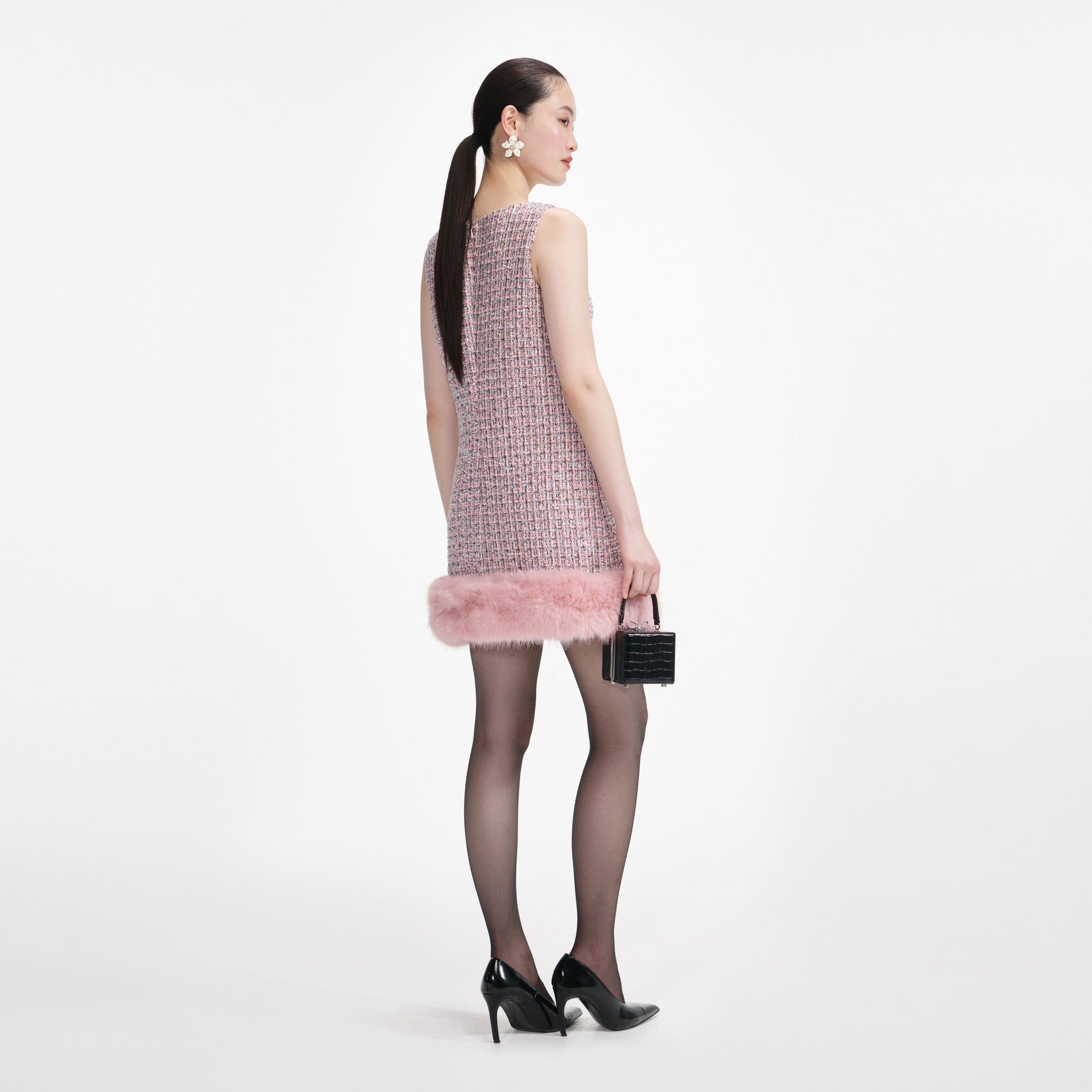 Back view of a woman wearing the Pink Boucle Fur Hem Mini Dress