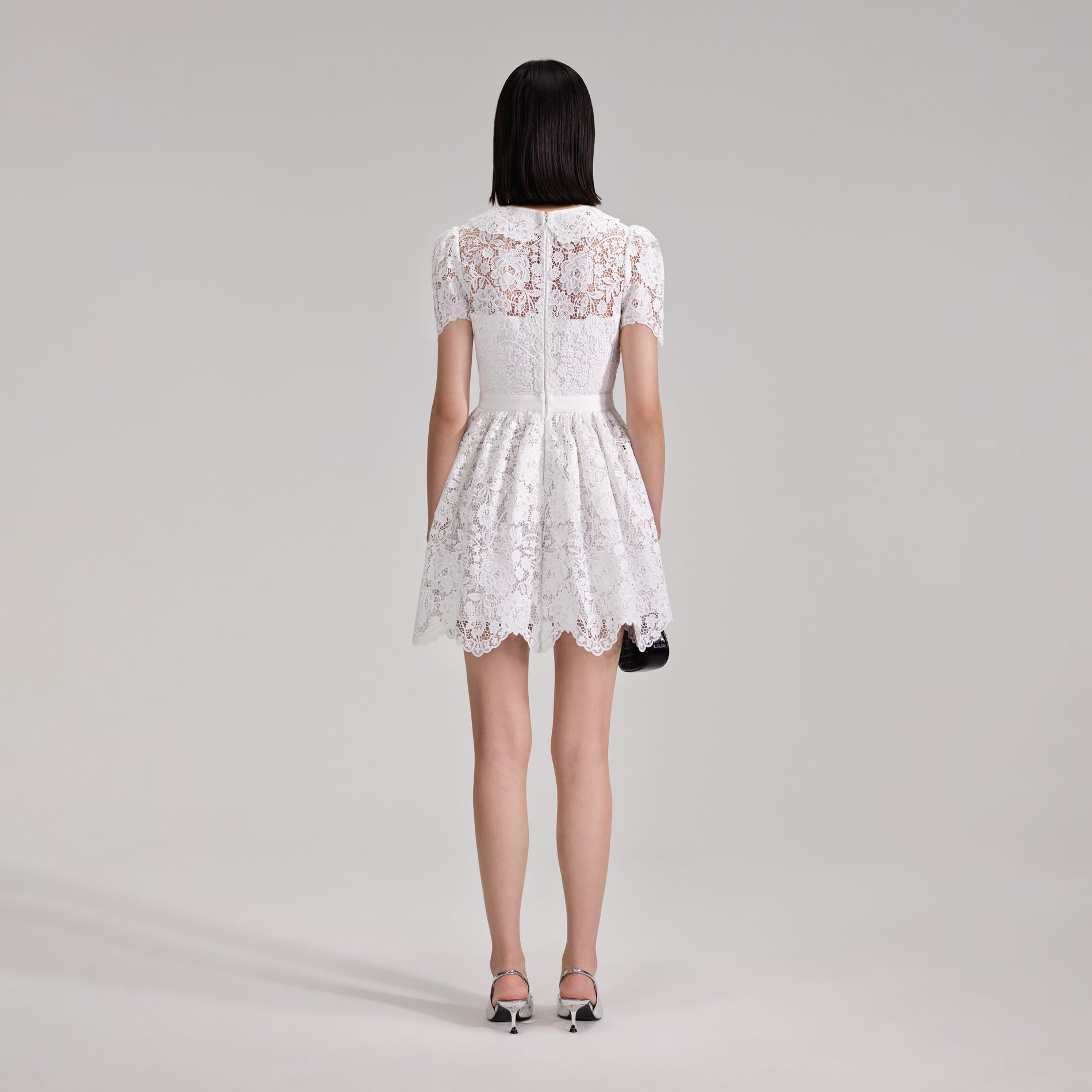 A woman wearing the White Cord Lace Collar Mini Dress