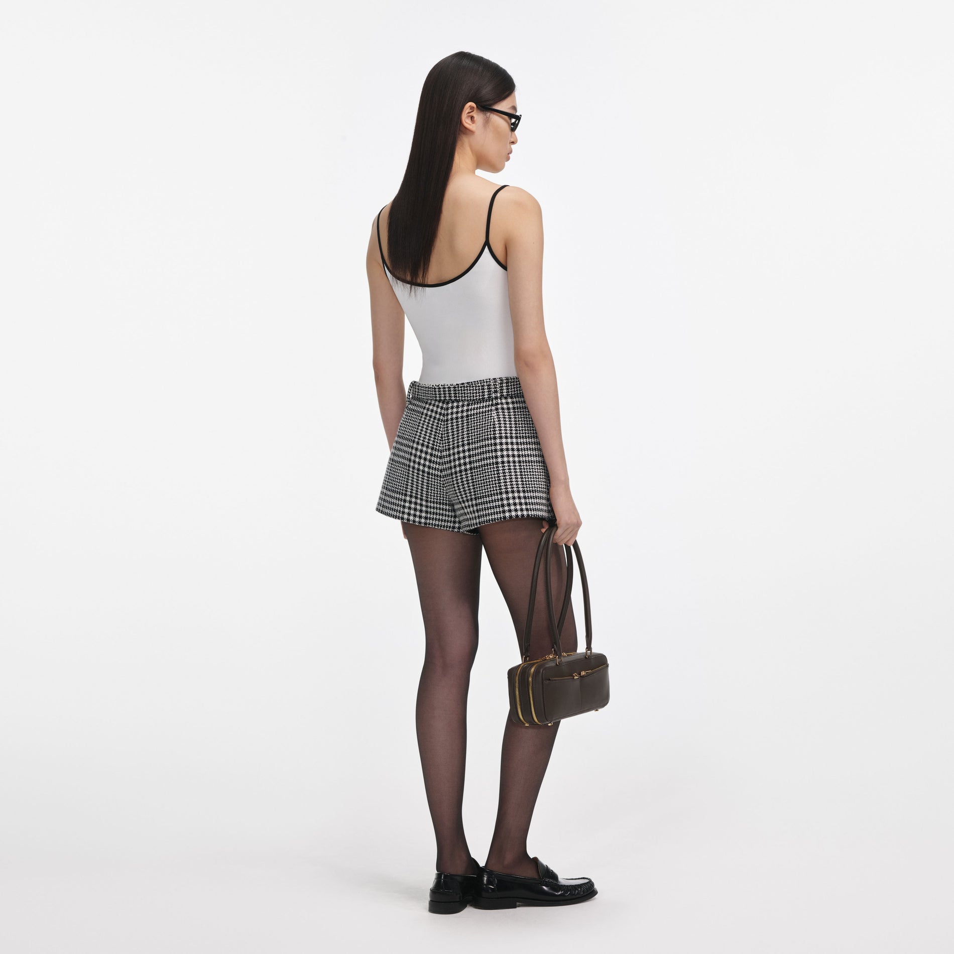 Back view of a woman wearing the White Vest With Black Logo