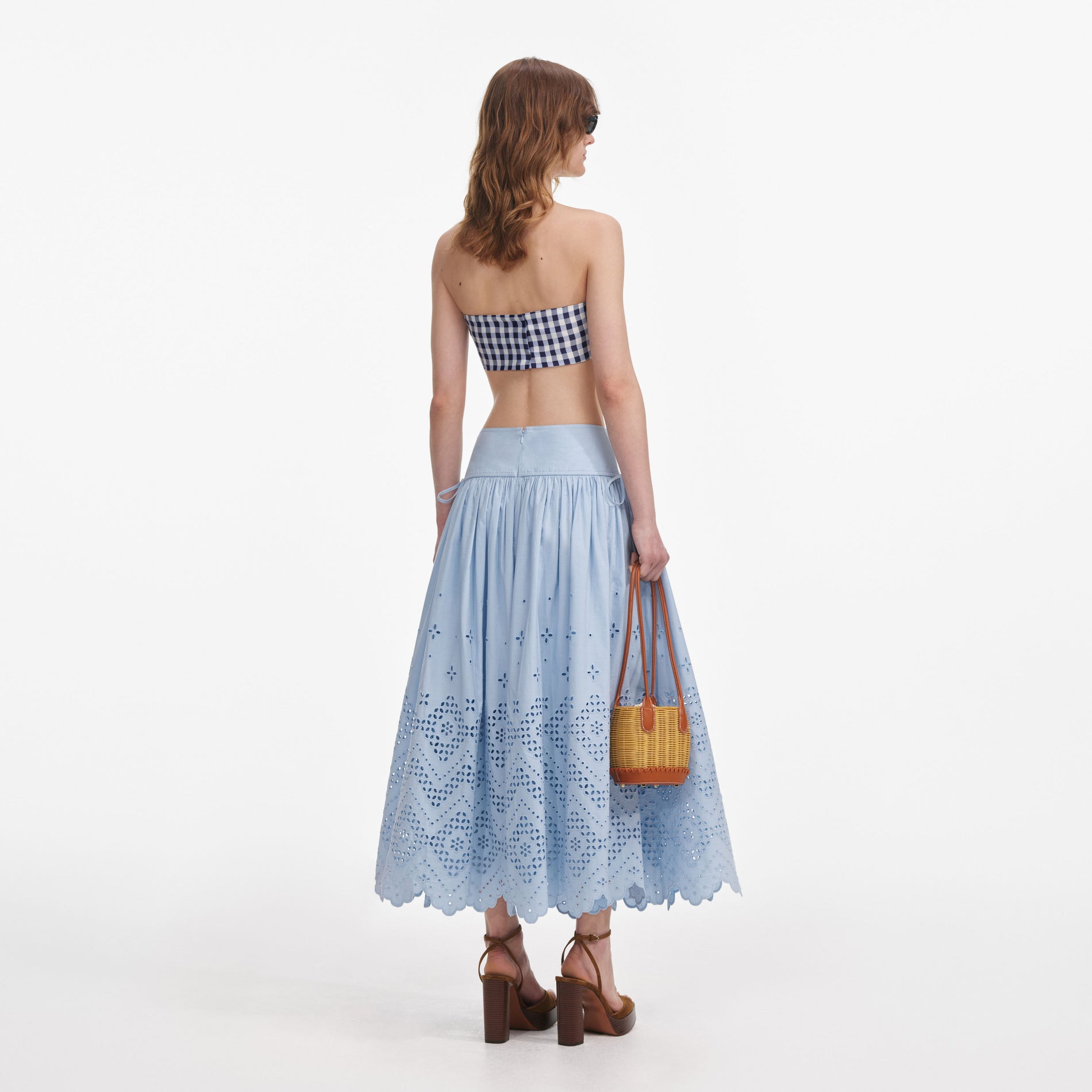 Back view of a woman wearing the Blue Cotton Broderie Midi Skirt