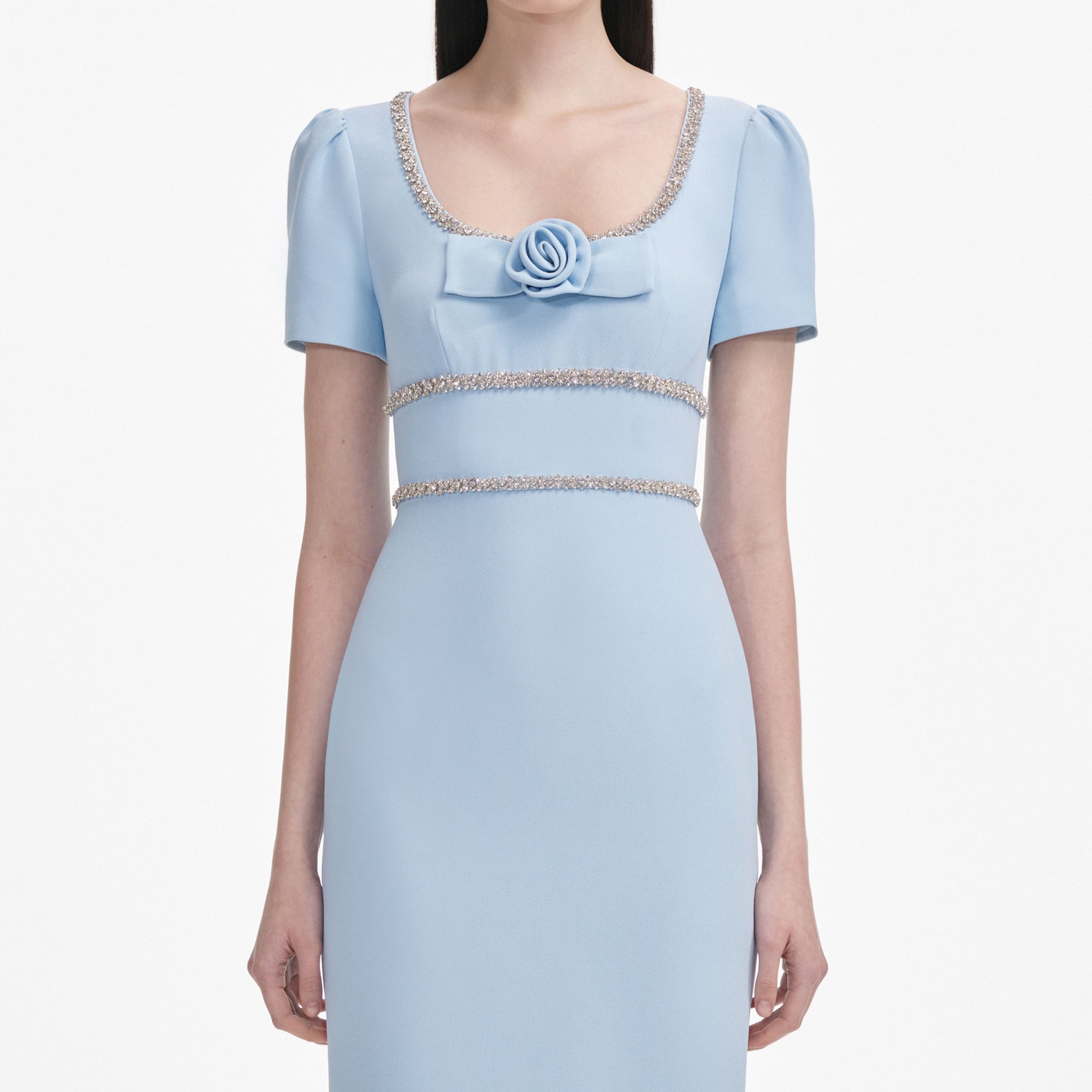 A close up of a woman wearing the Blue Crepe Crystal Trim Maxi Dress