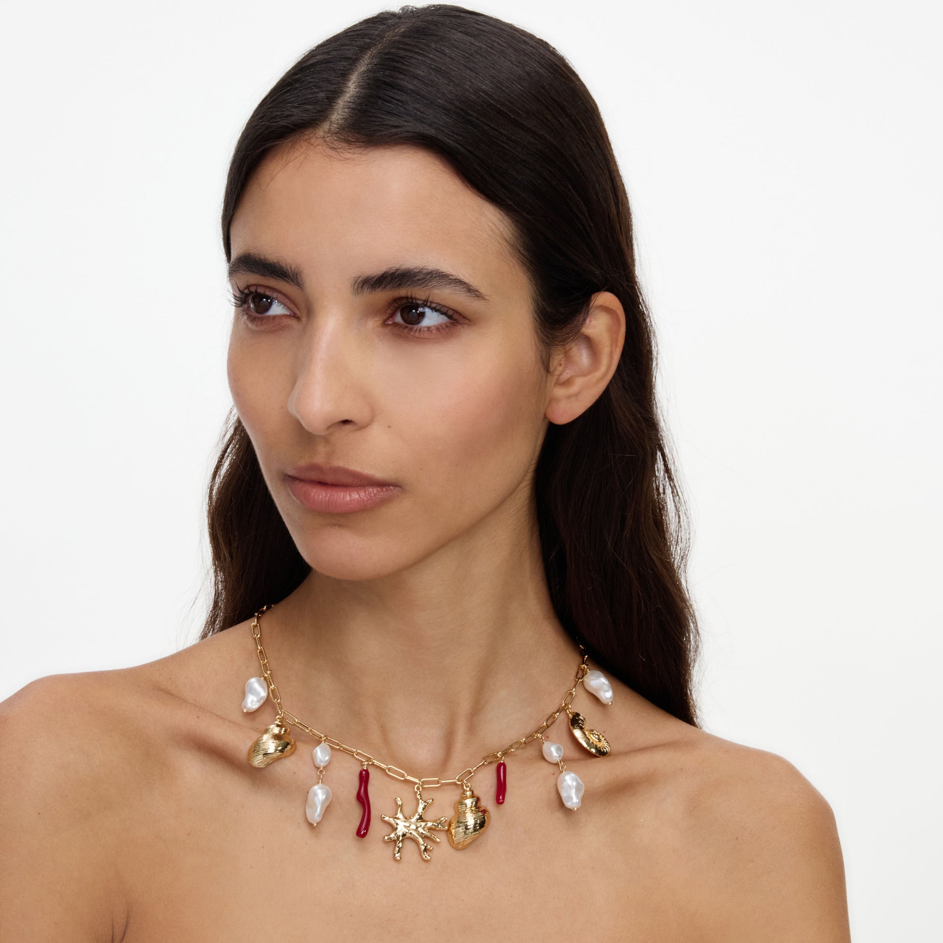 A close up of a woman wearing the Gold Coral Pearl Charm Necklace