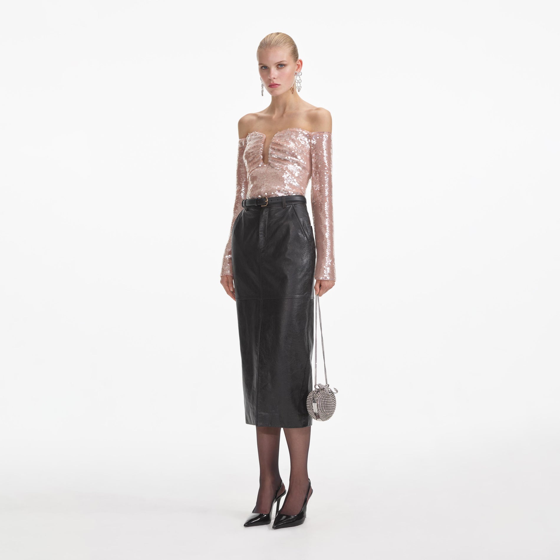 Side view of a woman wearing the Black Leather Midi Skirt