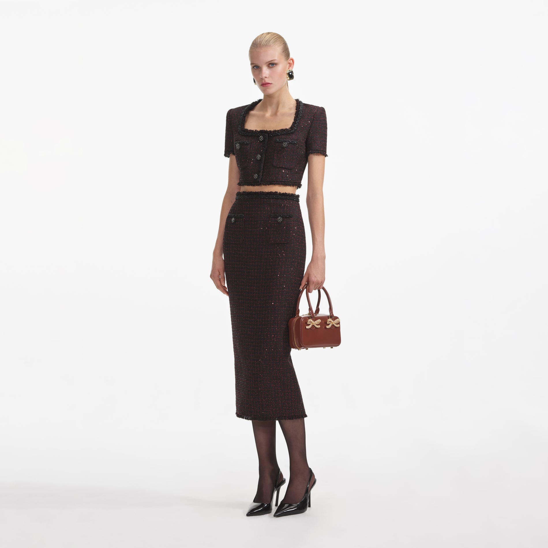 Side view of a woman wearing the Black Metallic Boucle Midi Skirt