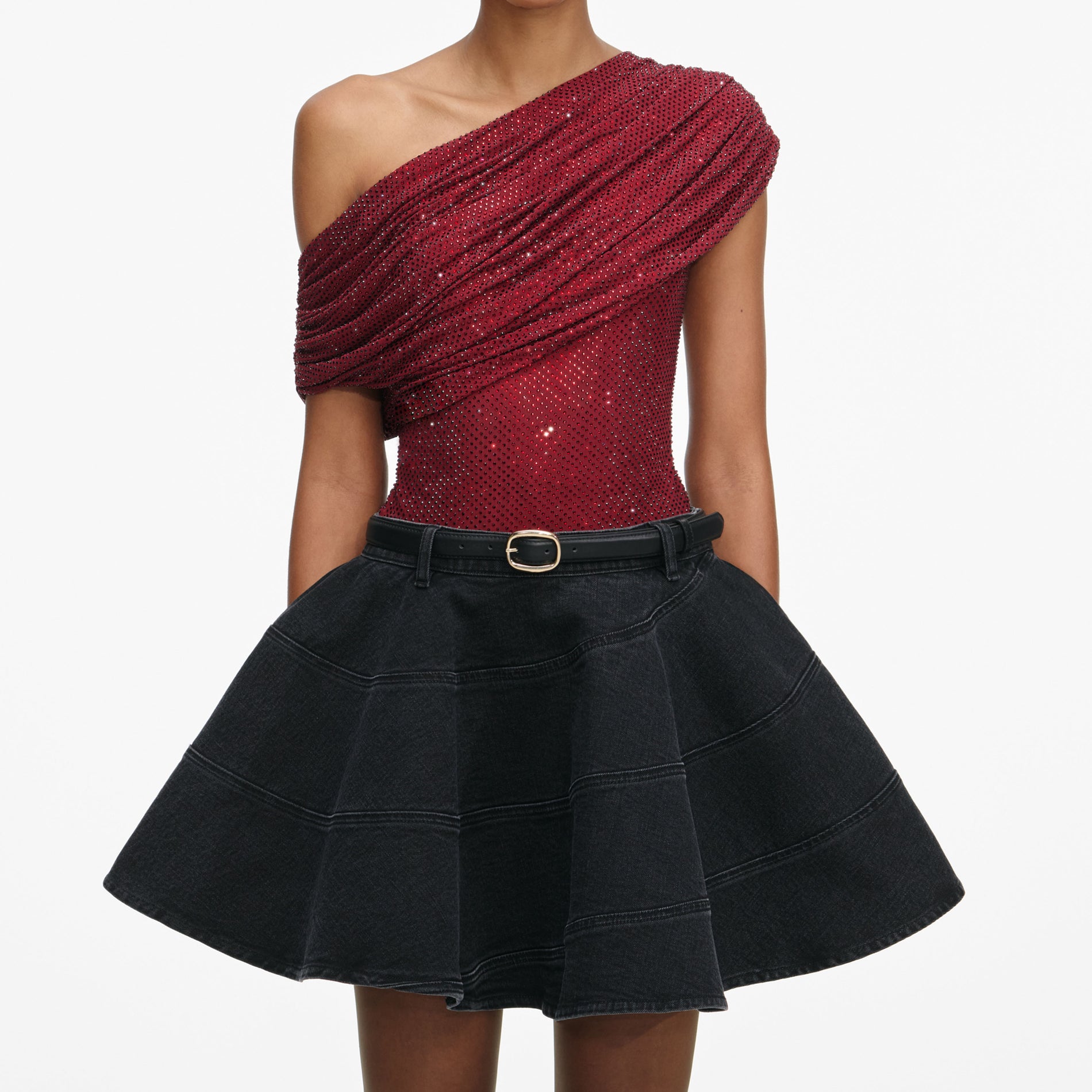 A close up of a woman wearing the Black Flared Denim Mini Skirt