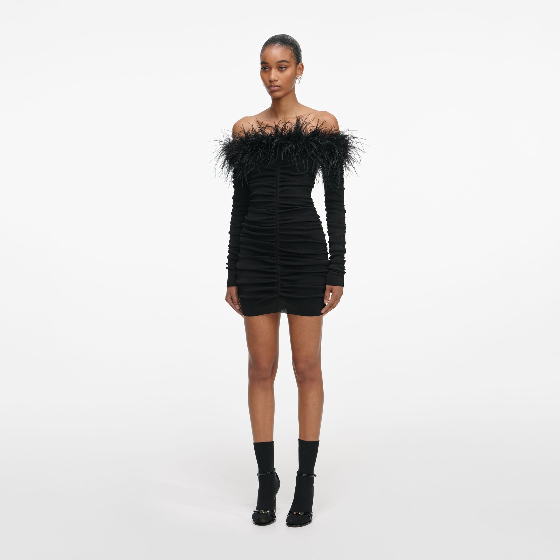 Side view of a woman wearing the Black Feather Viscose Knit Mini Dress