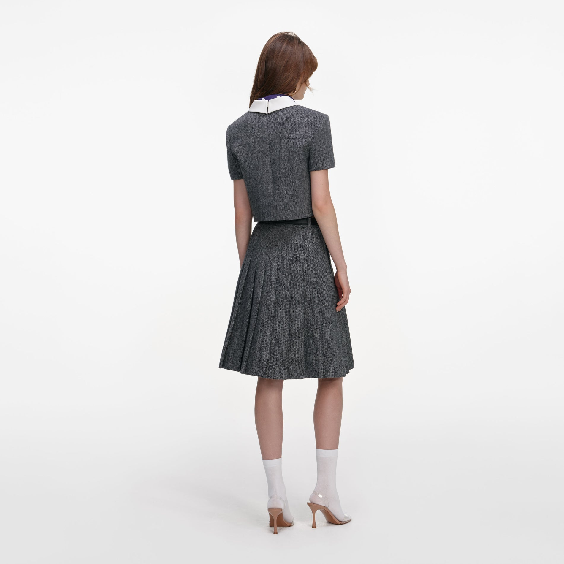 Back view of a woman wearing the Grey Herringbone Scarf Detail Top