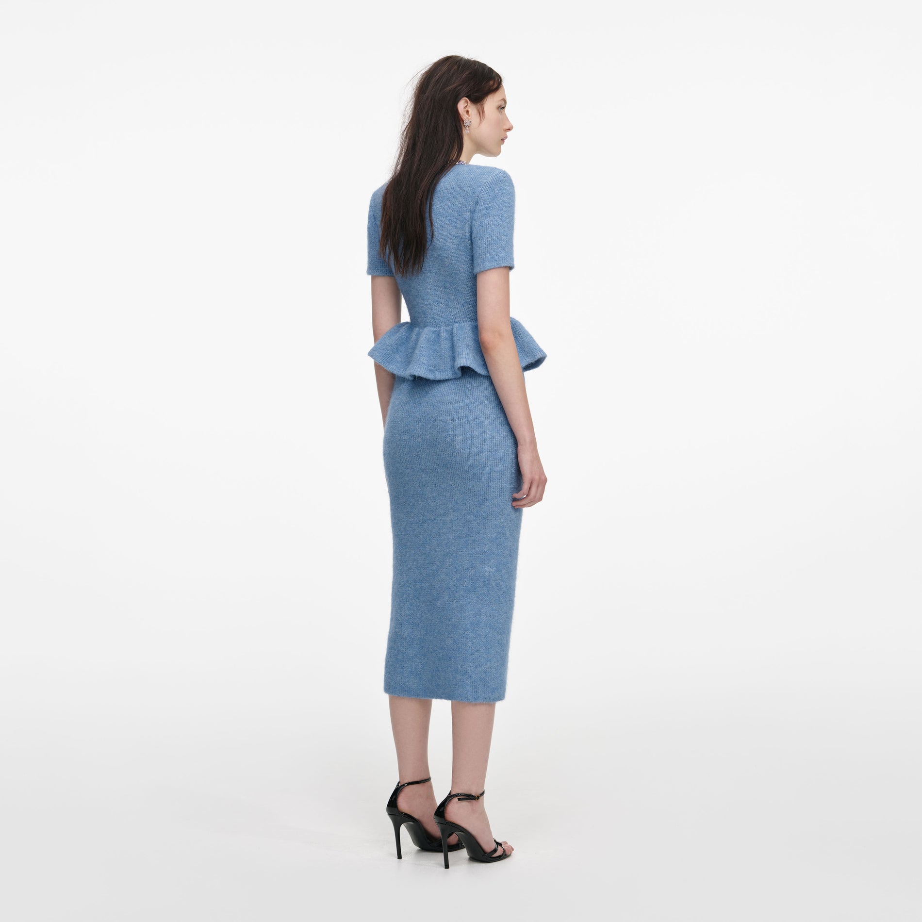 Back view of a woman wearing the Blue Peplum Knit Midi Dress