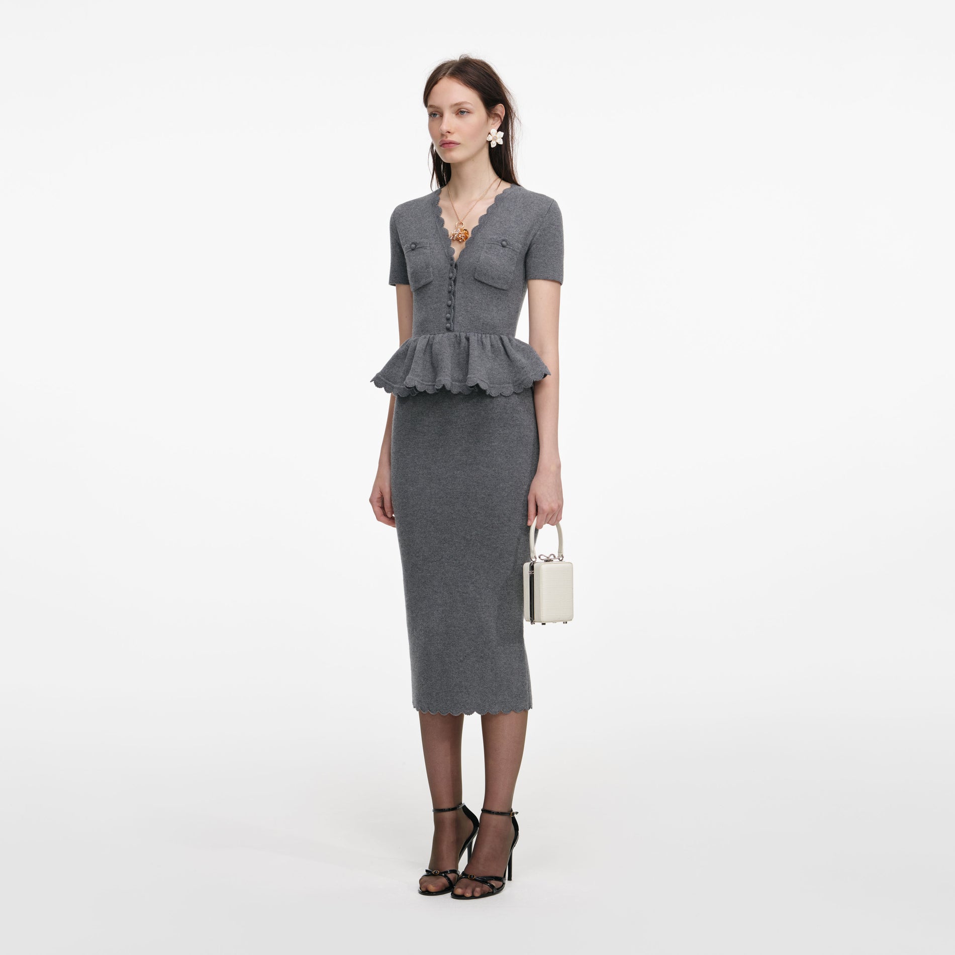 Side view of a woman wearing the Grey Peplum Knit Midi Dress
