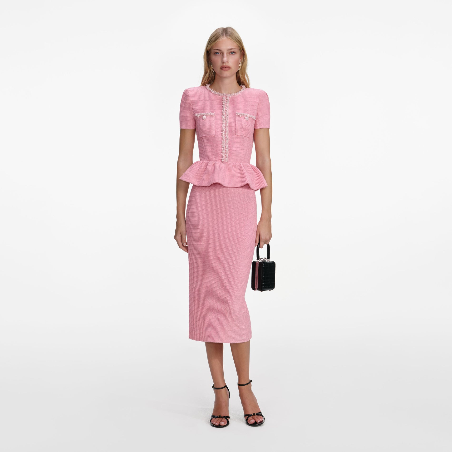 Front view of a woman wearing the Pink Peplum Knit Midi Dress