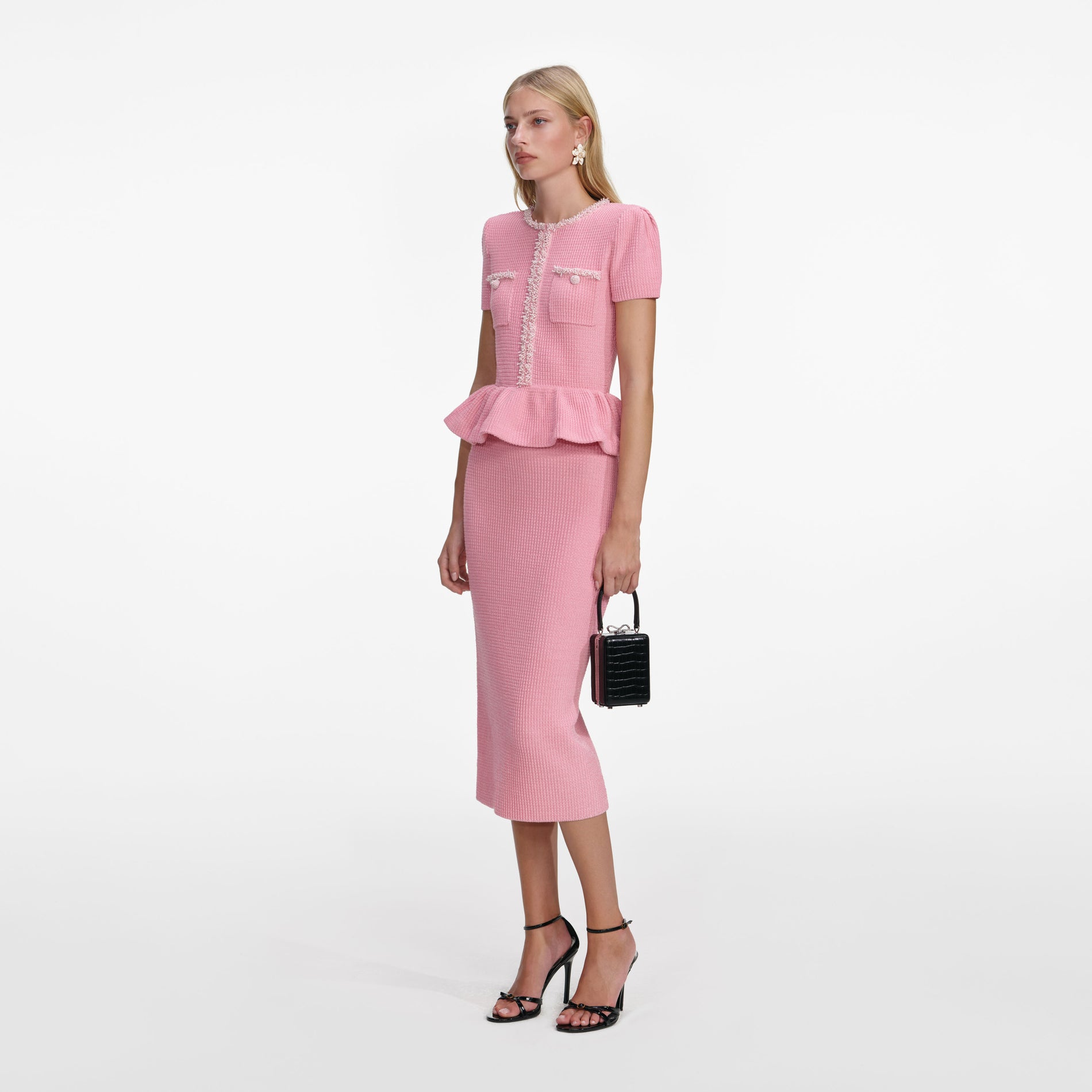Side view of a woman wearing the Pink Peplum Knit Midi Dress