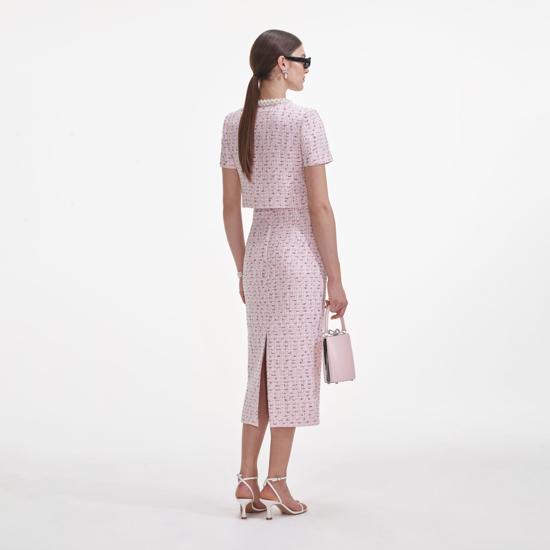 Back view of a woman wearing the Pink Boucle Pearl Midi Skirt