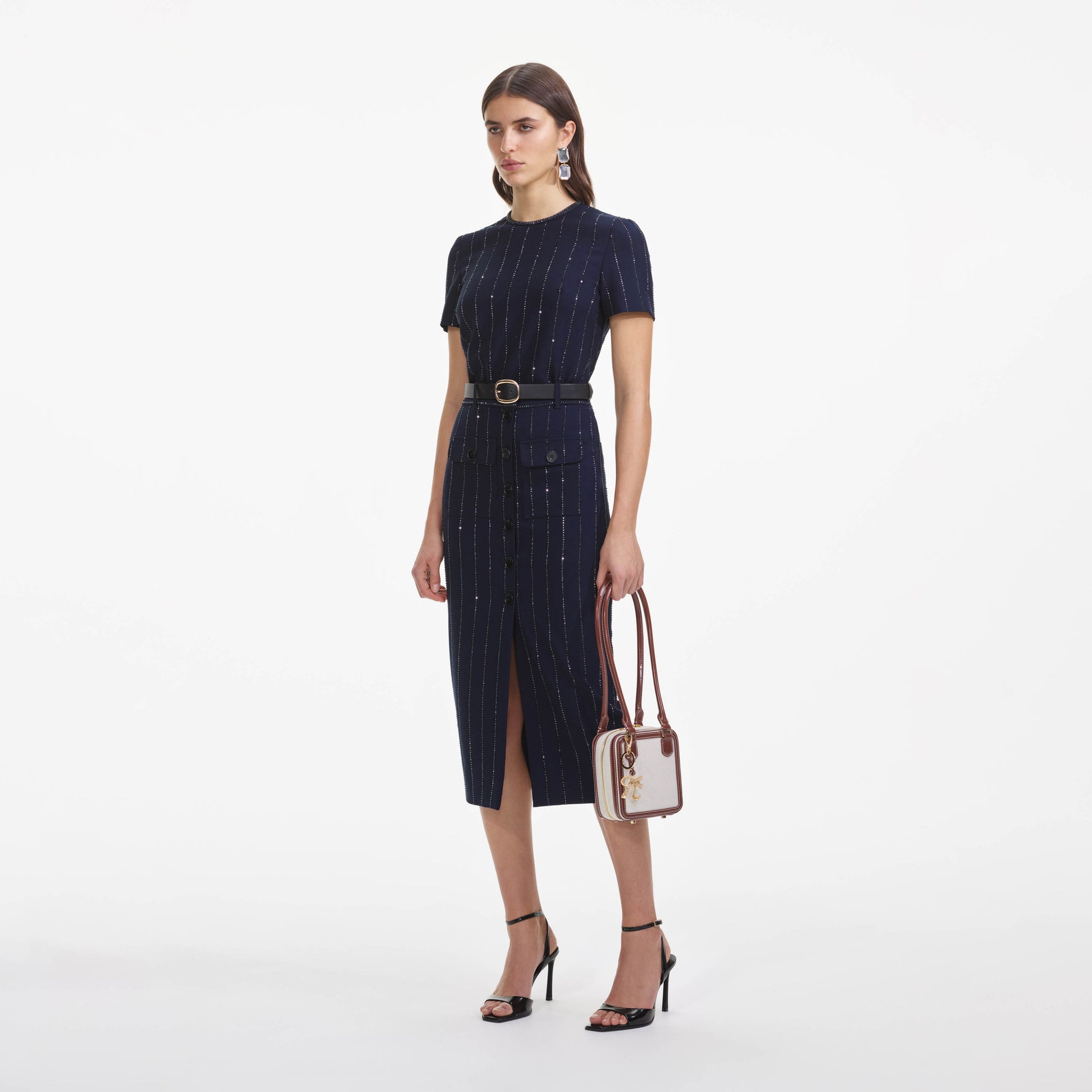 Side view of a woman wearing the Navy Rhinestone Pinstripe Midi Skirt
