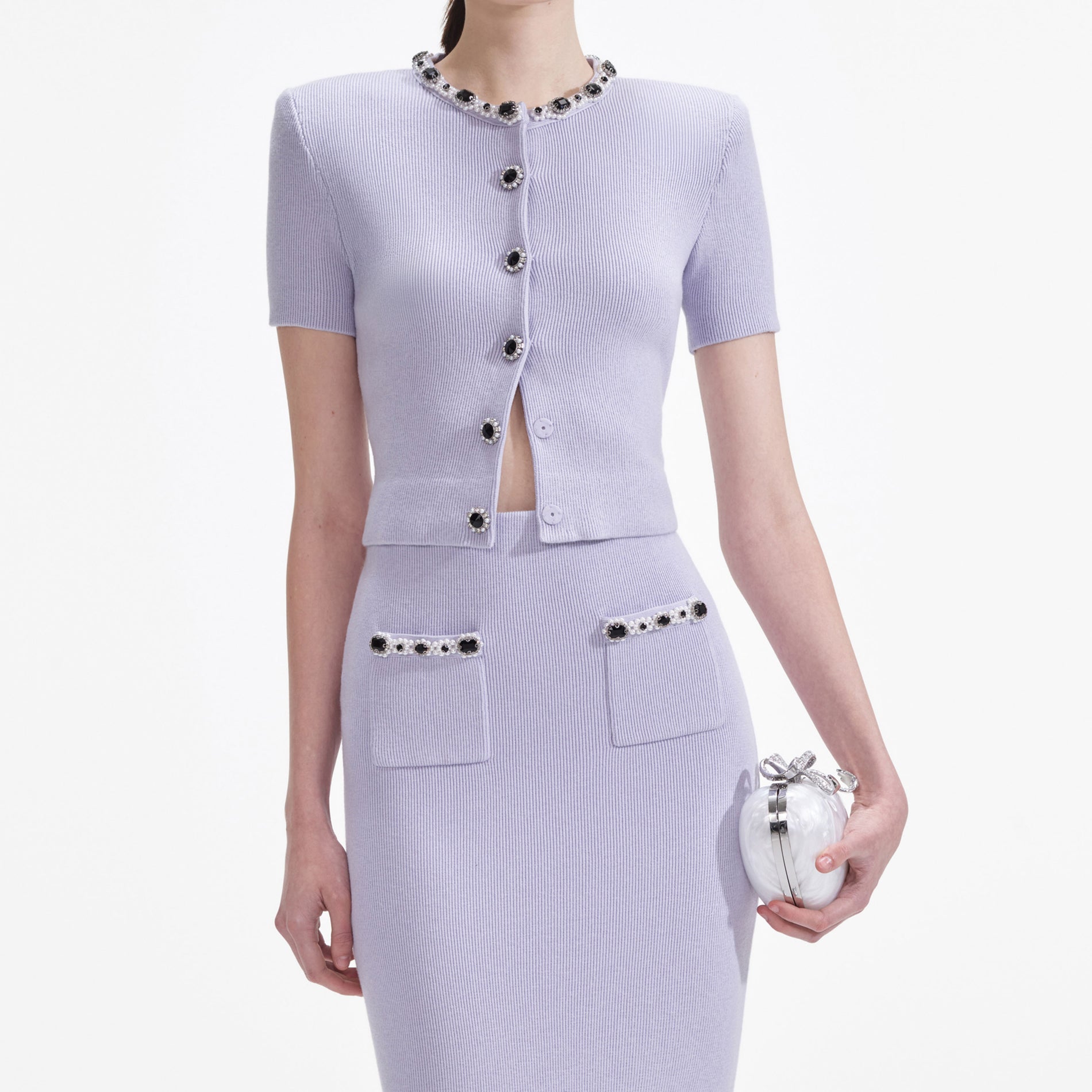 A close up of a woman wearing the Lilac Embellished Knit Top