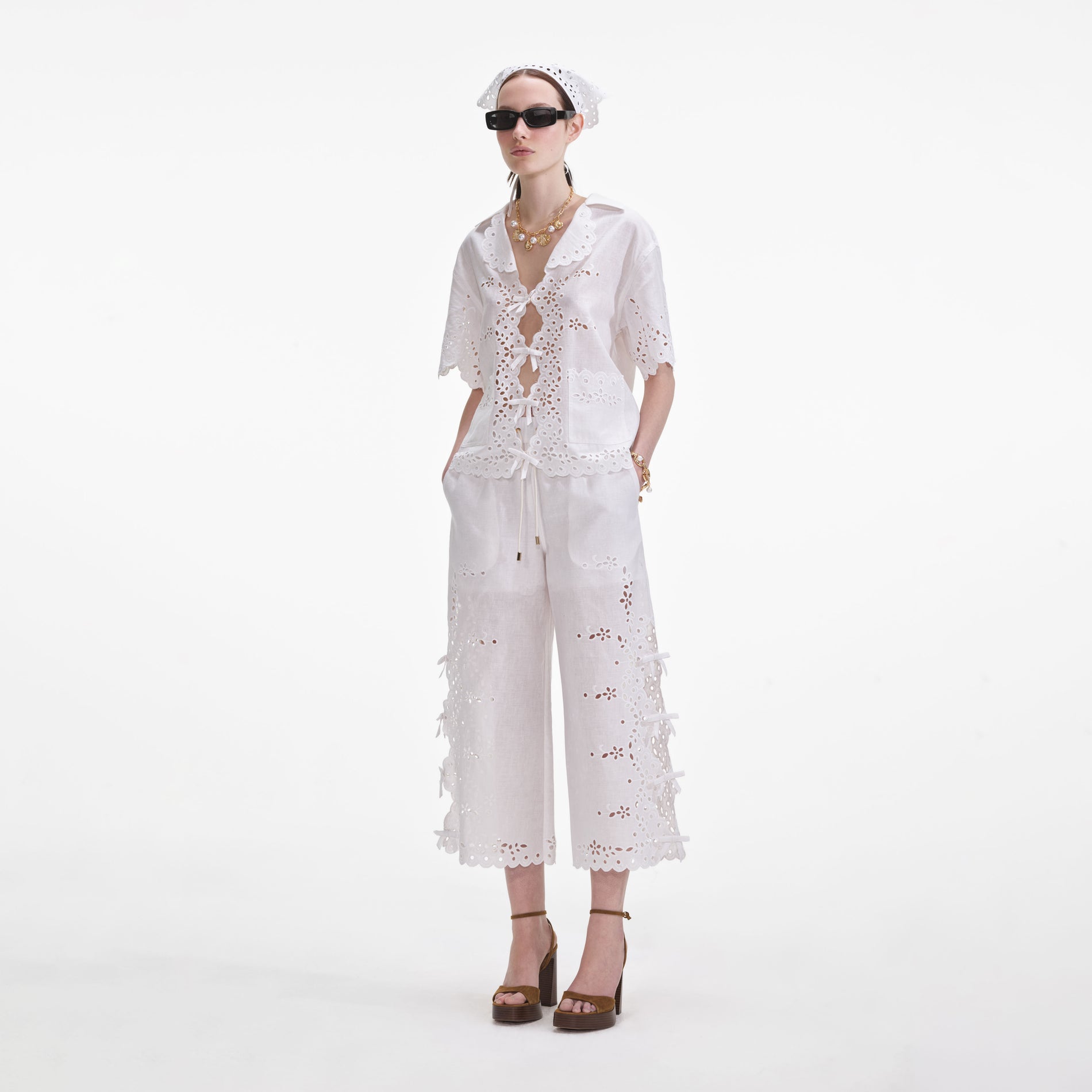 Side view of a woman wearing the Cream Linen Embroidered Trousers