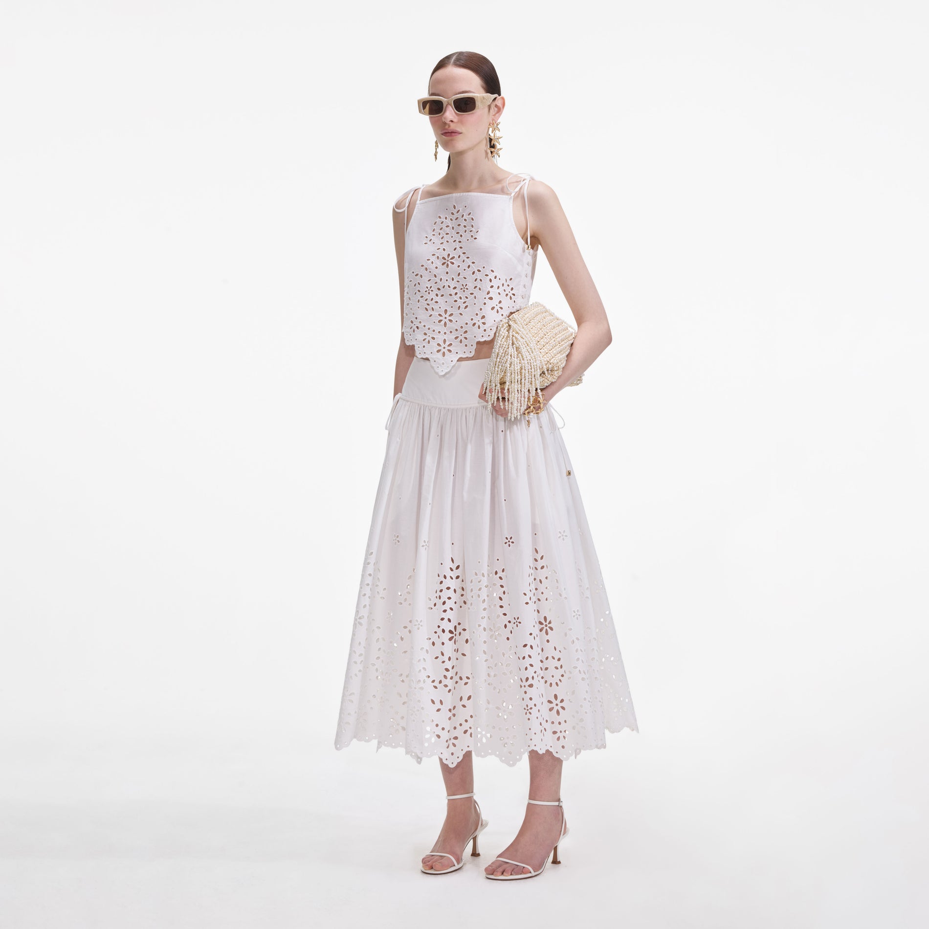 Side view of a woman wearing the White Cotton Embroidered Midi Skirt