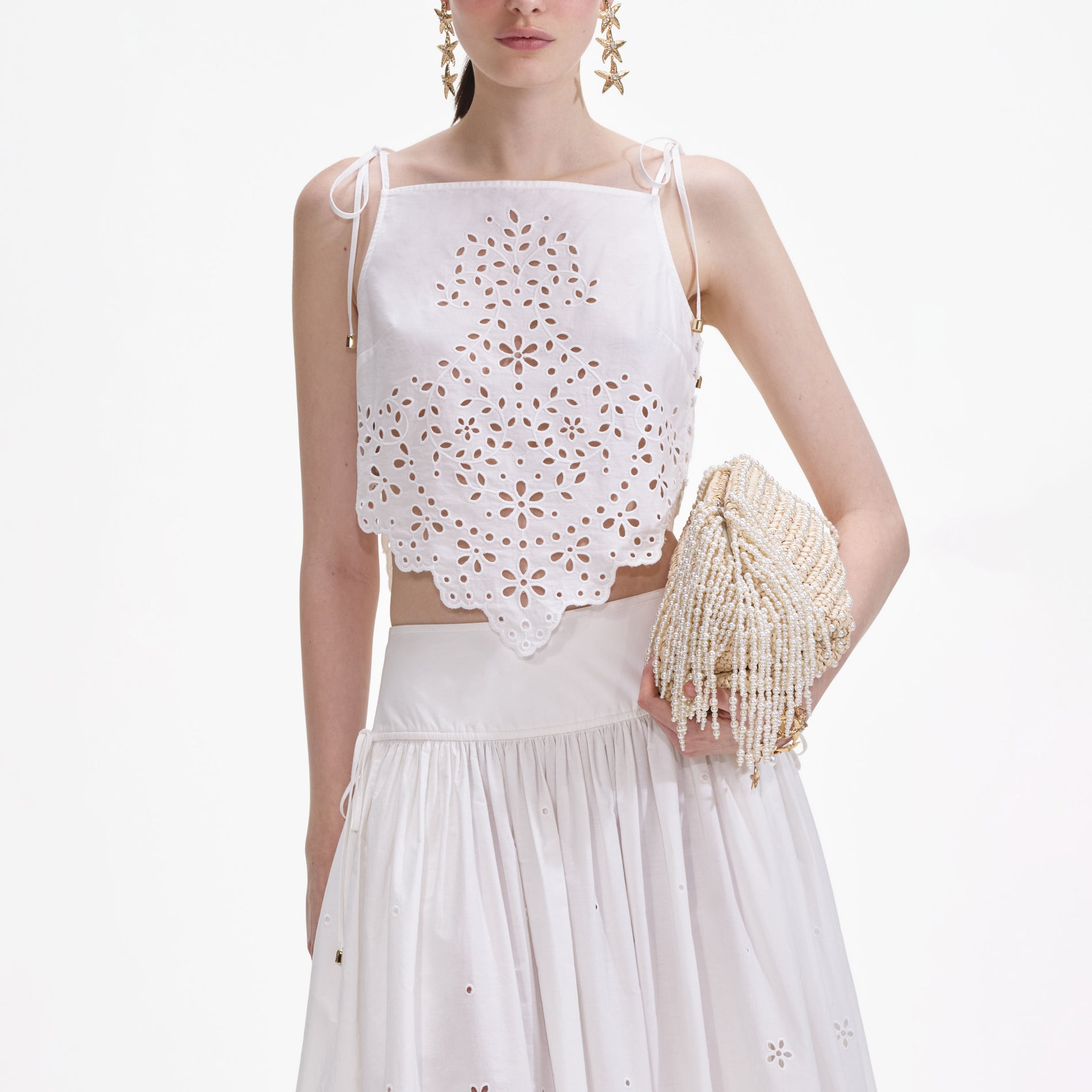 A close up of a woman wearing the White Cotton Embroidered Midi Skirt
