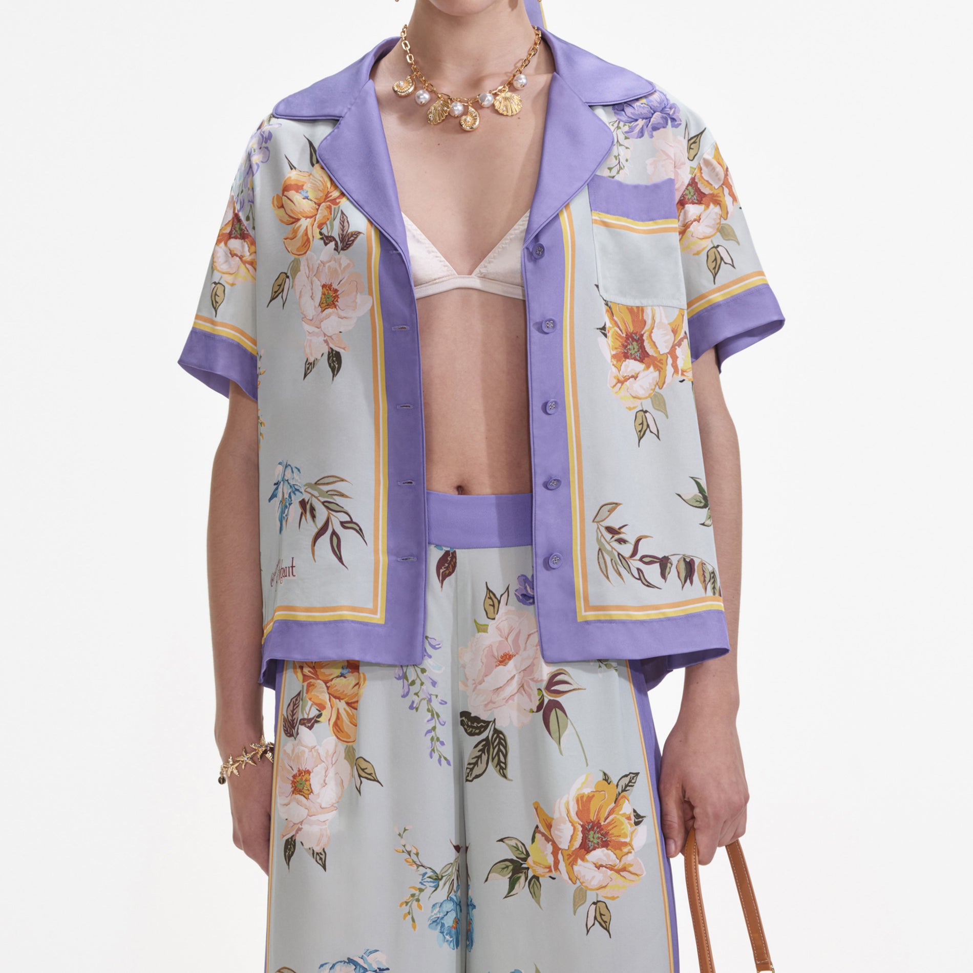 A close up of a woman wearing the Blue Floral Viscose Trousers