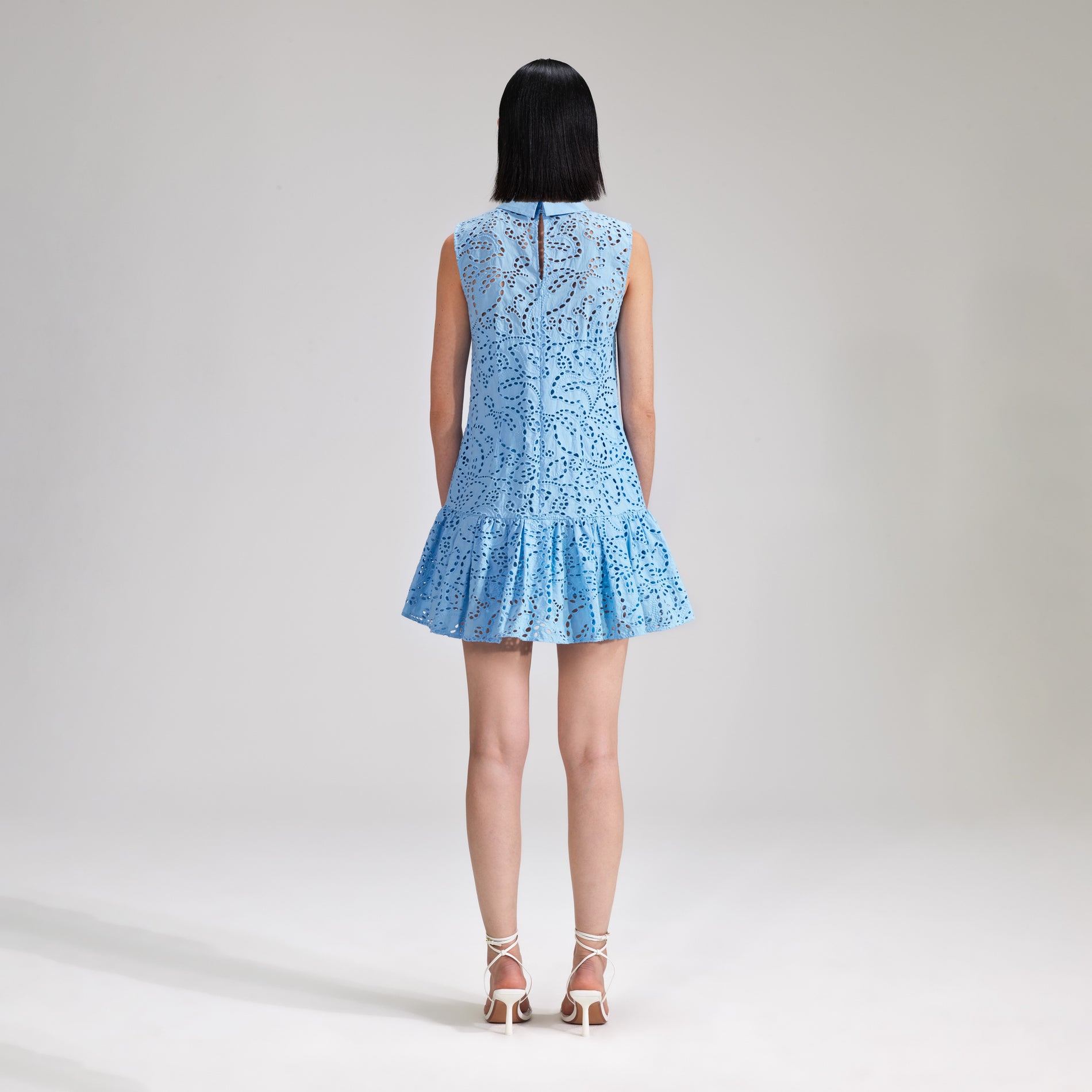 A woman wearing the Blue Broderie Mini Dress
