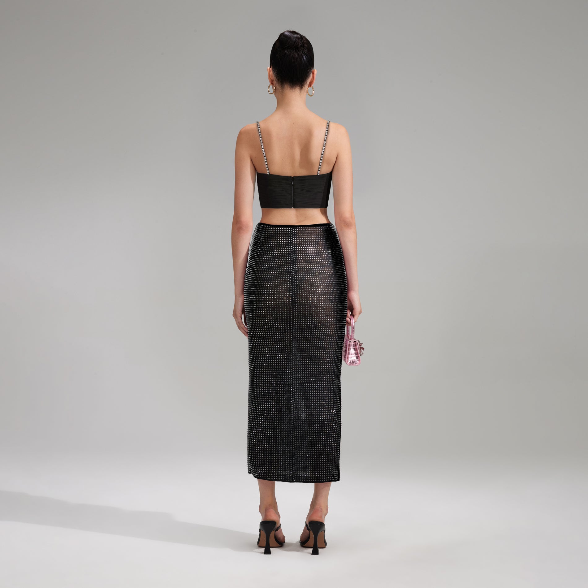 A woman wearing the Black Rhinestone Midi Skirt